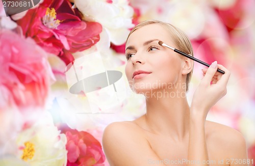 Image of beautiful woman with makeup brush