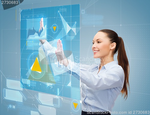 Image of smiling businesswoman working with virtual screen