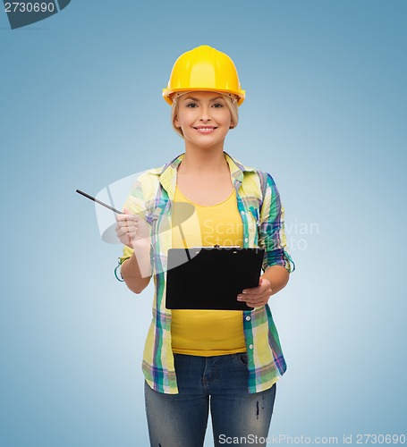 Image of smiling woman in helmet with clipboard