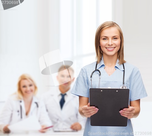 Image of smiling female doctor or nurse with clipboard