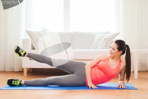 Image of smiling teenage girl doing exercise for legs