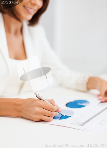 Image of businesswoman working with graphs in office
