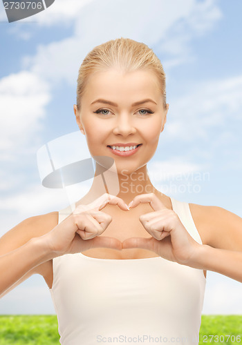 Image of smiling woman showing heart shape gesture