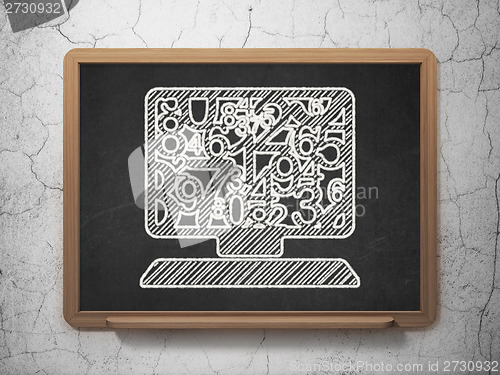 Image of Education concept: Computer Pc on chalkboard background