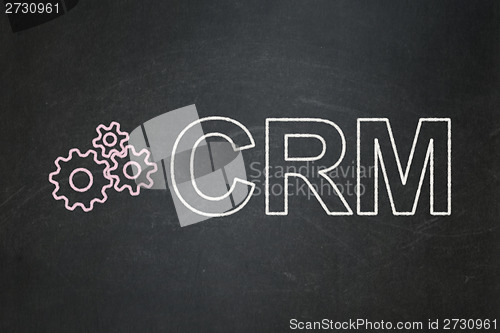 Image of Finance concept: Gears and CRM on chalkboard background