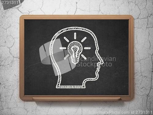 Image of Education concept: Head With Lightbulb on chalkboard background