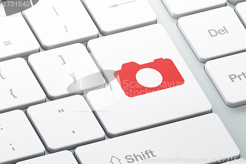 Image of Travel concept: Photo Camera on computer keyboard background