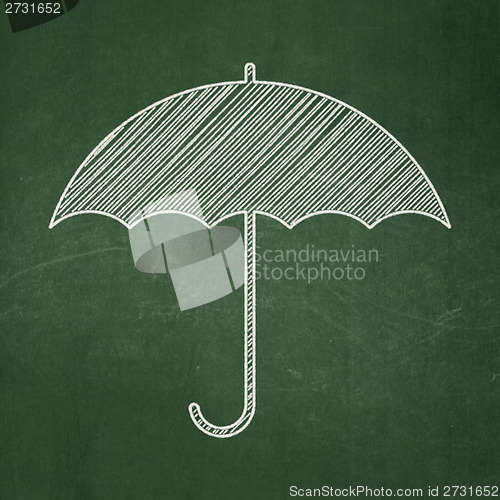 Image of Protection concept: Umbrella on chalkboard background