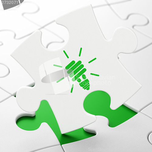 Image of Business concept: Energy Saving Lamp on puzzle background
