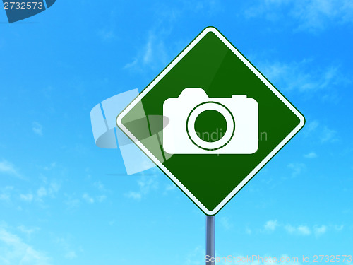 Image of Travel concept: Photo Camera on road sign background