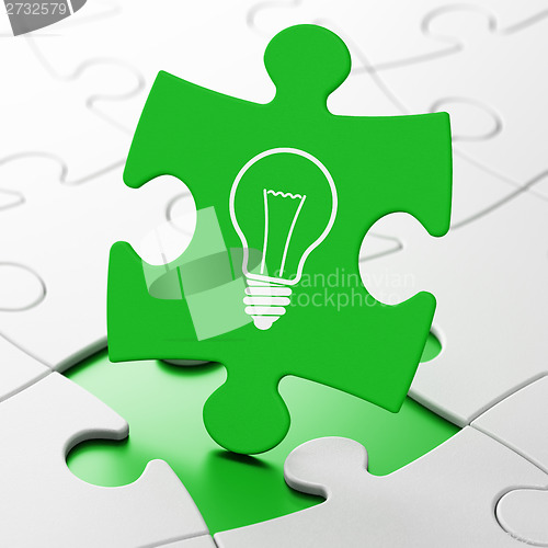 Image of Business concept: Light Bulb on puzzle background