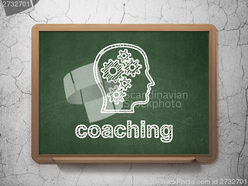 Image of Education concept: Head With Gears and Coaching on chalkboard background