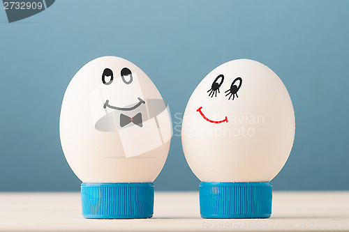 Image of Two white eggs with smiles, male and female, man and woman.