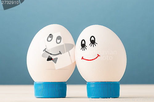 Image of Two white eggs with smiles, male and female, man and woman.