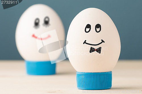 Image of Two white eggs with smiles, male and female, man and woman.