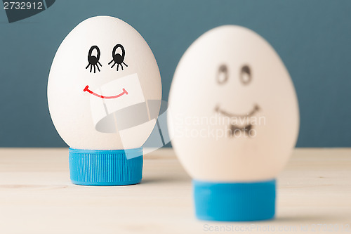 Image of Two white eggs with smiles, male and female, man and woman.