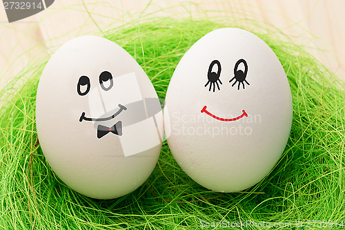 Image of Two white eggs with smiles, male and female, man and woman.