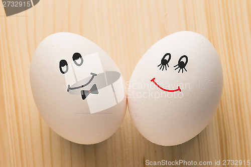 Image of Two white eggs with smiles, male and female, man and woman.