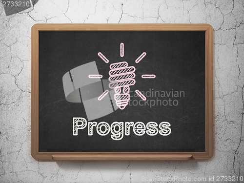 Image of Business concept: Energy Saving Lamp and Progress on chalkboard background