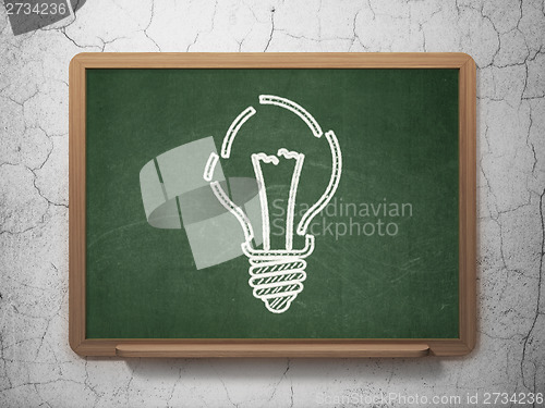 Image of Finance concept: Light Bulb on chalkboard background
