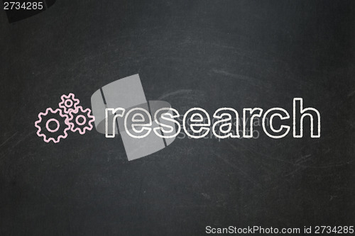 Image of Advertising concept: Gears and Research on chalkboard background