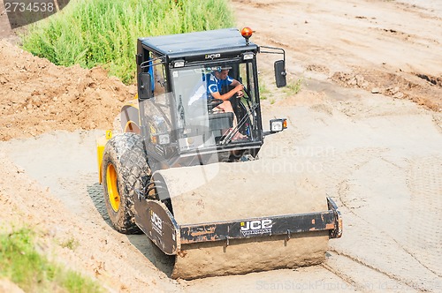 Image of Road roller compressing sand to highway