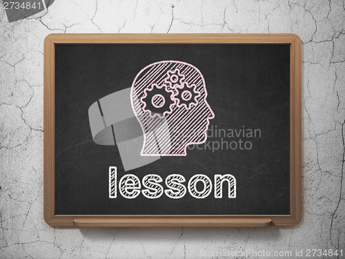 Image of Education concept: Head With Gears and Lesson on chalkboard