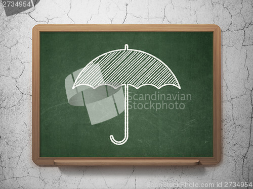 Image of Security concept: Umbrella on chalkboard background