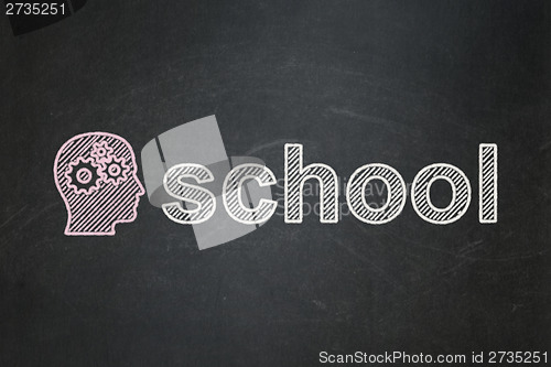 Image of Education concept: Head With Gears and School on chalkboard