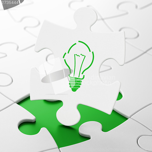 Image of Finance concept: Light Bulb on puzzle background