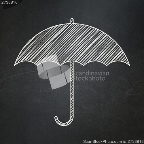 Image of Security concept: Umbrella on chalkboard background