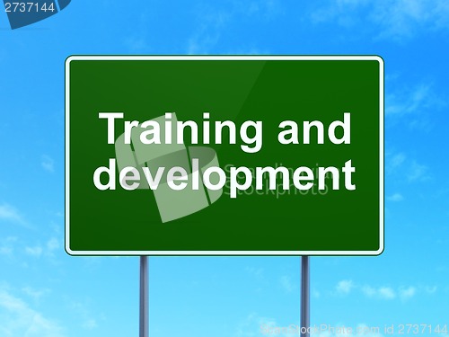 Image of Education concept: Training and Development on road sign background