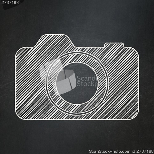 Image of Tourism concept: Photo Camera on chalkboard background