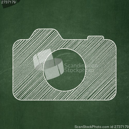 Image of Travel concept: Photo Camera on chalkboard background