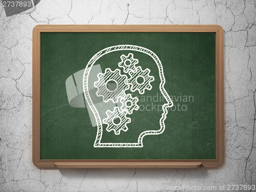 Image of Education concept: Head With Gears on chalkboard background