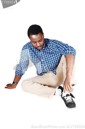 Image of Black man sitting on floor.