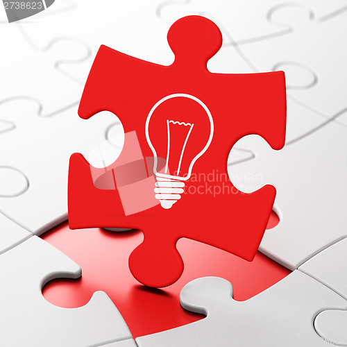 Image of Finance concept: Light Bulb on puzzle background