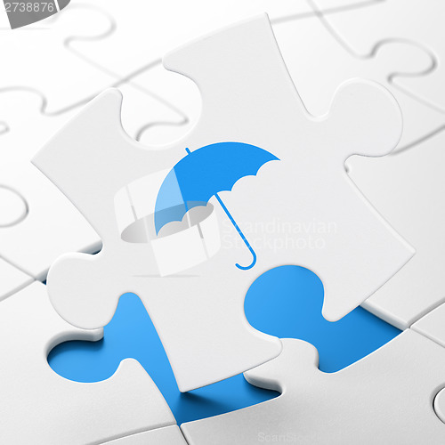 Image of Safety concept: Umbrella on puzzle background