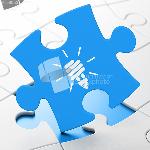 Image of Business concept: Energy Saving Lamp on puzzle background