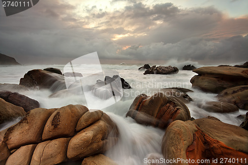 Image of Ocean surges over weathered rocks