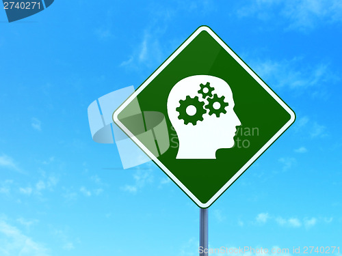 Image of Finance concept: Head With Gears on road sign background