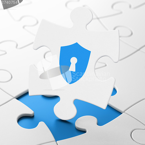 Image of Security concept: Shield With Keyhole on puzzle background