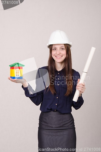 Image of Girl stands with a house builder and drawing in hands