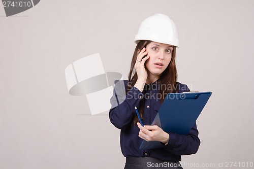 Image of young girl is shocked by what he heard on phone