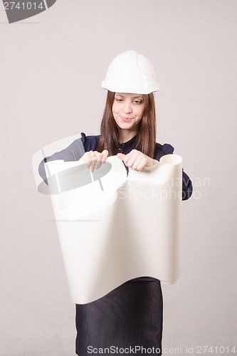 Image of Woman architect in helmet drawing tears