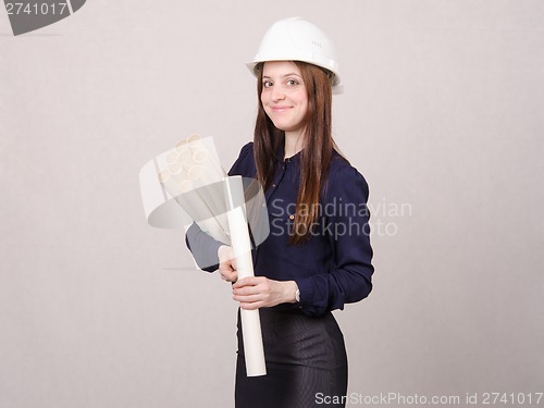 Image of Student stands with blueprints in hand