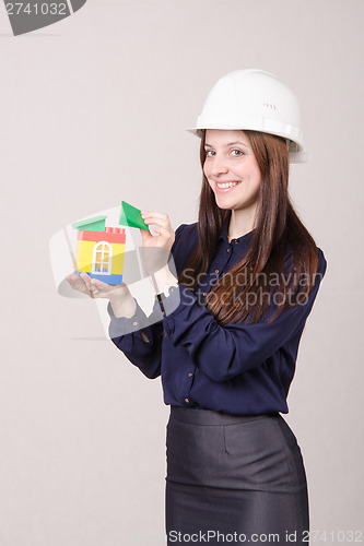 Image of Construction worker stands with a house in the hands of