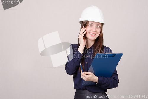 Image of woman in hard hat talking to a customer on phone
