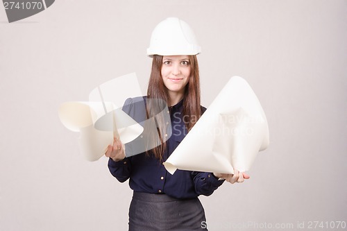 Image of Woman architect in helmet drawing tears