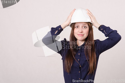 Image of Frustrated young girl put her hands on his helmet